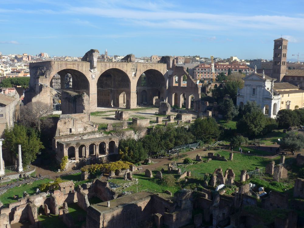La Basilica di Massenzio vista dal Palatino. Le tre grandi arcate appartengono alla navata settentrionale, l’unica conservata quasi per intero. La veduta permette di percepire le dimensioni monumentali dell’edificio e l’articolazione degli ambienti coperti da immense volte a botte [Foto: Maria Teresa Natale, CC BY-NC-SA]