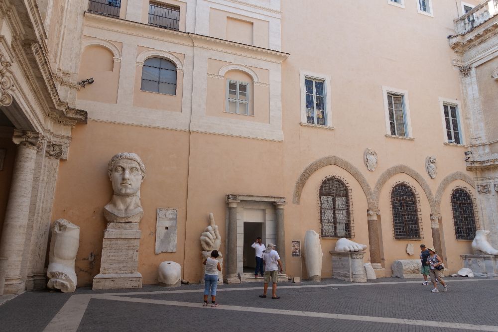 Roma, Musei Capitolini, cortile del Palazzo dei Conservatori. Frammenti originali del Colosso di Costantino, 313-324 d.C. La testa, la mano, i piedi e le altre parti marmoree appartenevano a una statua acrolitica dell’imperatore seduto, alta originariamente tra i dieci e i dodici metri. I frammenti furono rinvenuti nel 1486 nella Basilica di Massenzio  [Foto: Maria Teresa Natale, CC BY-NC-SA]